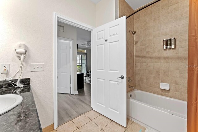 bathroom featuring ceiling fan, tile patterned flooring, vanity, and shower / tub combo