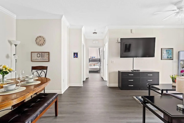 living area featuring crown molding, baseboards, ceiling fan, and dark wood-style flooring