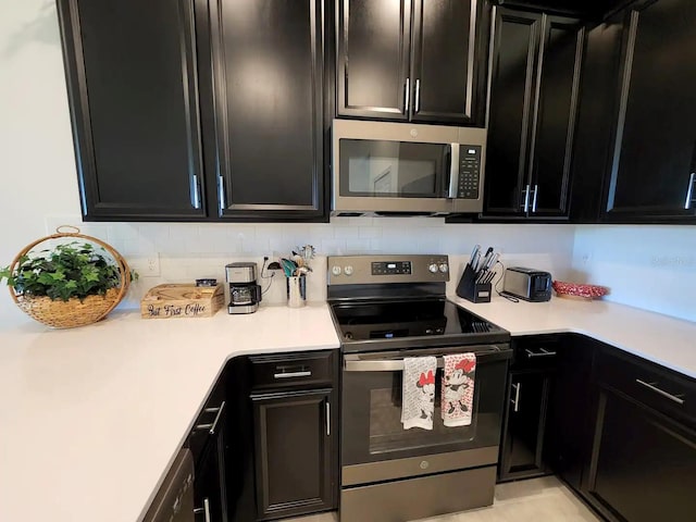 kitchen with appliances with stainless steel finishes and backsplash