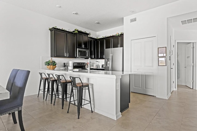 kitchen featuring appliances with stainless steel finishes, light tile patterned floors, and kitchen peninsula