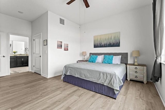 bedroom featuring light hardwood / wood-style floors, ceiling fan, and ensuite bathroom