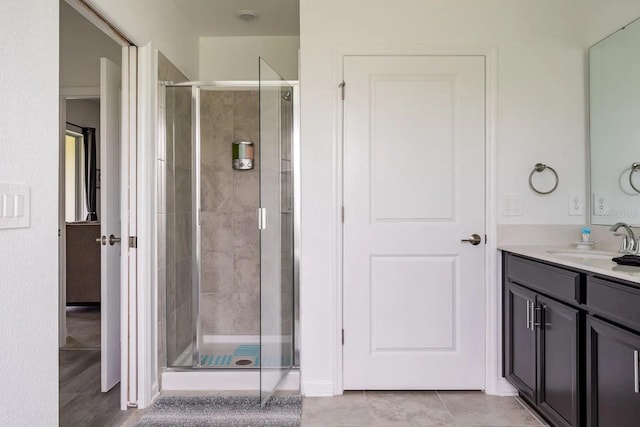 bathroom featuring tile patterned floors, walk in shower, and vanity