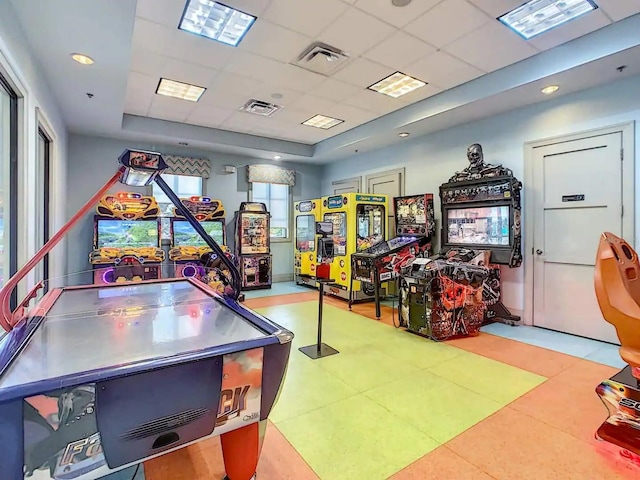 playroom featuring light tile patterned floors and a paneled ceiling