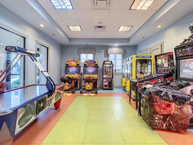 rec room featuring a raised ceiling, a paneled ceiling, and tile patterned flooring