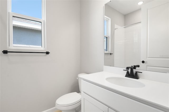 bathroom with vanity, toilet, and a shower