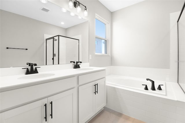 bathroom featuring vanity and independent shower and bath