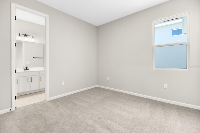 unfurnished bedroom with sink and light carpet