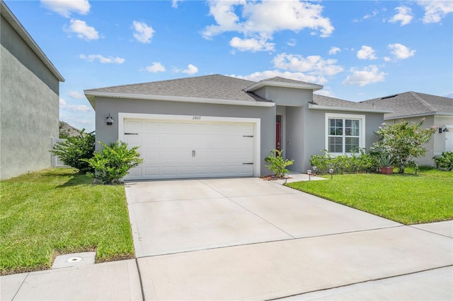 view of front of home with an attached garage, driveway, a front lawn, and stucco siding