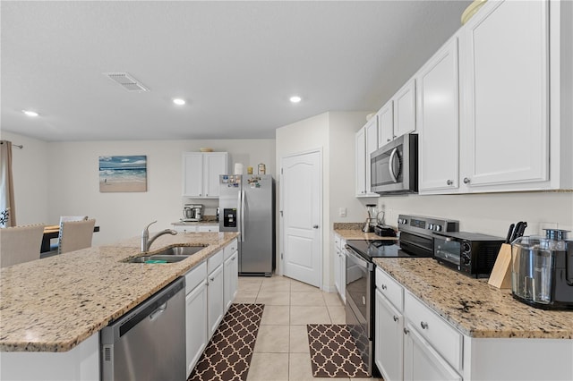 kitchen with light tile patterned floors, stainless steel appliances, visible vents, white cabinetry, and a sink