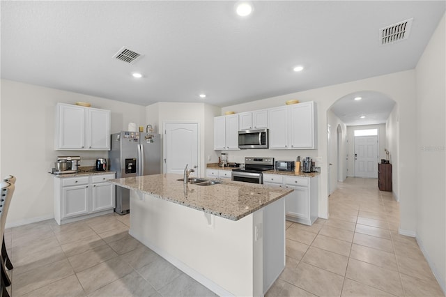 kitchen with sink, white cabinetry, a kitchen island with sink, light tile patterned floors, and stainless steel appliances