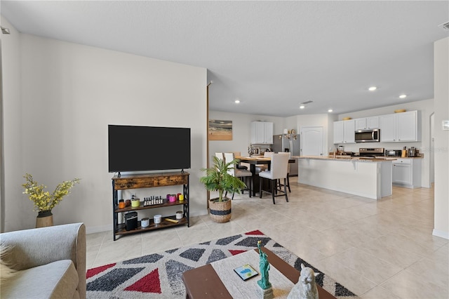 living area featuring recessed lighting, light tile patterned flooring, visible vents, and baseboards