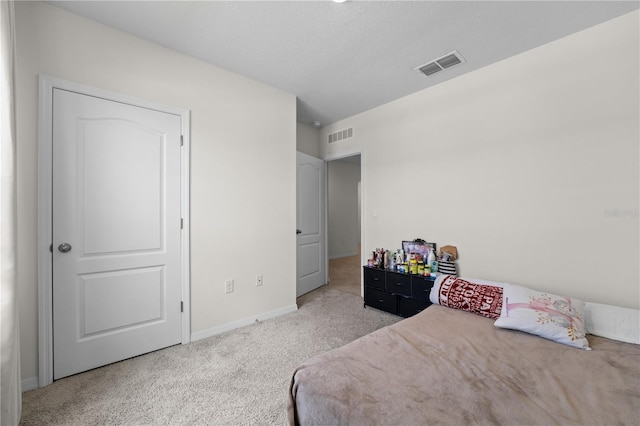 bedroom featuring light colored carpet, visible vents, and baseboards