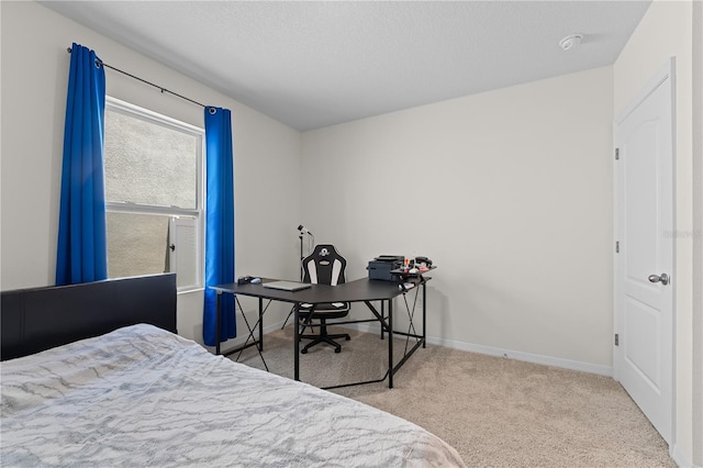 carpeted bedroom with a textured ceiling and baseboards