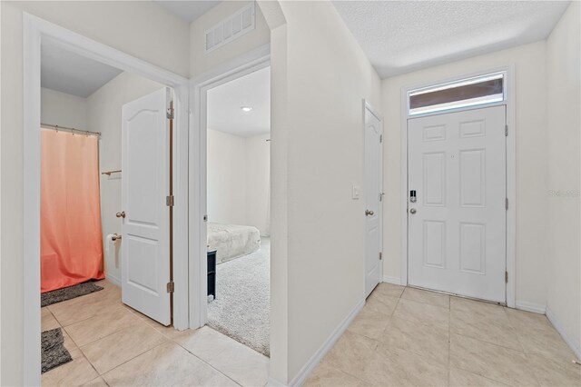 tiled entrance foyer with a textured ceiling