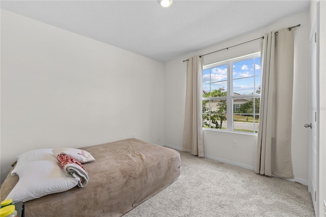 carpeted bedroom with a textured ceiling and baseboards