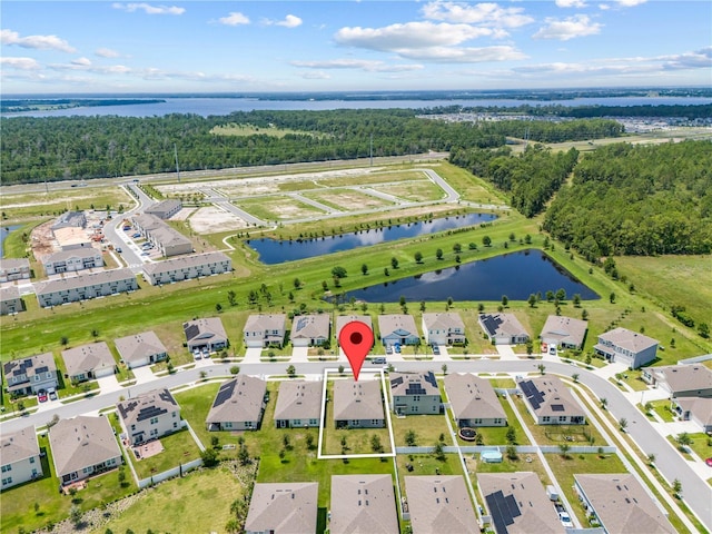 birds eye view of property with a water view, a wooded view, and a residential view