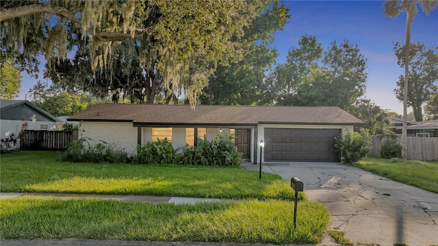 ranch-style home featuring a garage and a front lawn