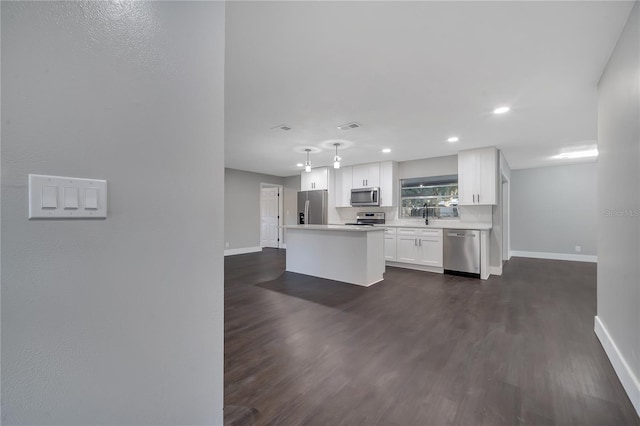 kitchen featuring a kitchen island, dark hardwood / wood-style flooring, white cabinets, appliances with stainless steel finishes, and sink