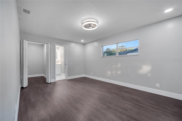 unfurnished bedroom with dark hardwood / wood-style flooring and ensuite bathroom