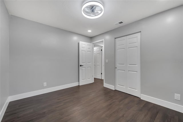 unfurnished bedroom featuring dark hardwood / wood-style floors and a closet