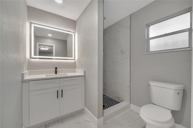 bathroom with tile patterned flooring, toilet, a tile shower, and vanity