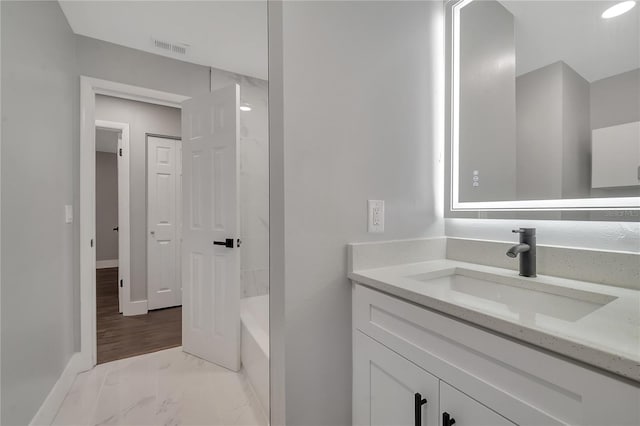 bathroom with hardwood / wood-style flooring, bathtub / shower combination, and vanity