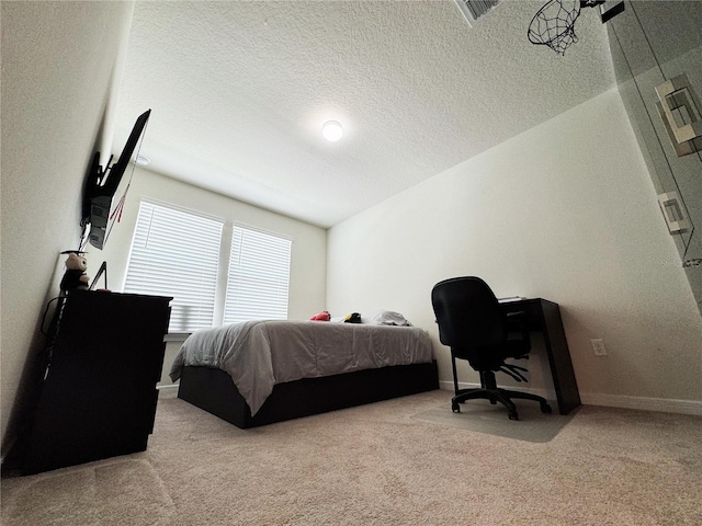 carpeted bedroom featuring a textured ceiling, visible vents, and baseboards