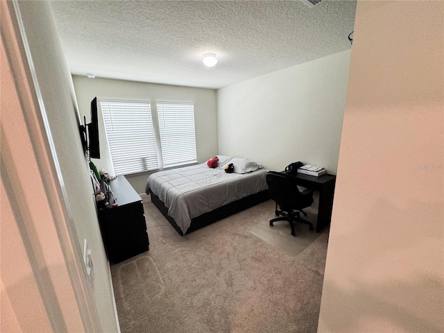 bedroom with carpet floors and a textured ceiling