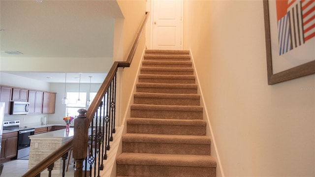 staircase with visible vents and baseboards