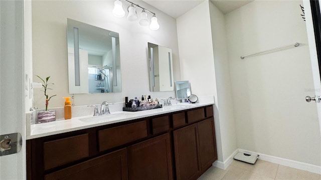 full bathroom with a sink, baseboards, and double vanity