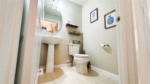 bathroom featuring baseboards, toilet, and tile patterned floors