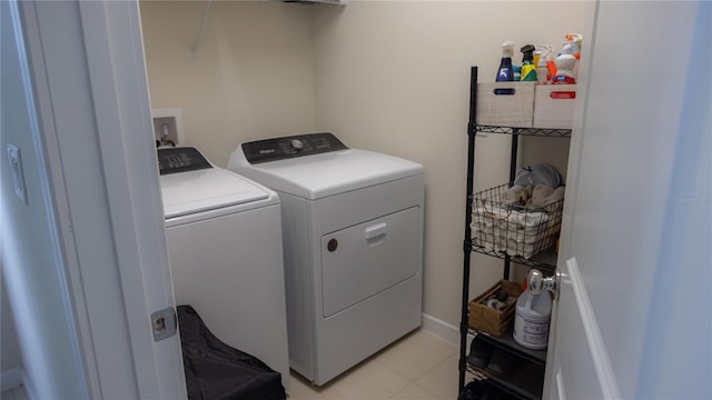 washroom featuring laundry area, washing machine and clothes dryer, and light tile patterned floors