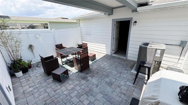 view of patio with central AC unit, fence, and outdoor dining space