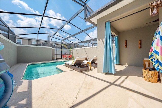 outdoor pool featuring glass enclosure and a patio area