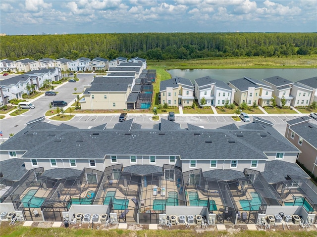 drone / aerial view with a forest view and a water view