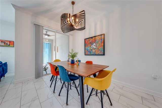 dining space with marble finish floor, baseboards, ornamental molding, and an inviting chandelier