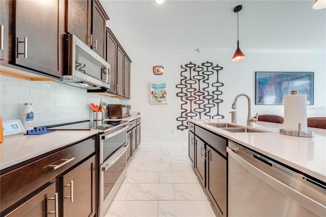 kitchen featuring dark brown cabinetry, a sink, marble finish floor, appliances with stainless steel finishes, and decorative light fixtures