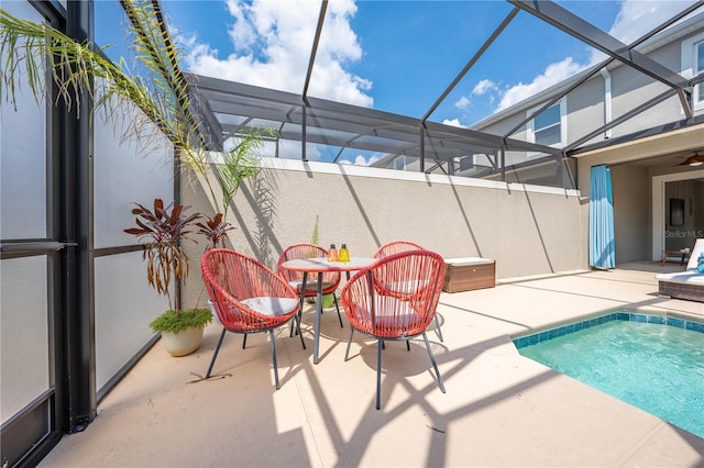 pool featuring glass enclosure and a patio