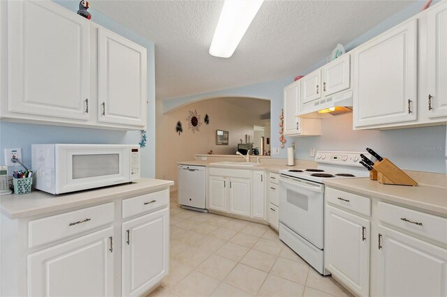 kitchen featuring white cabinetry, sink, a textured ceiling, light tile patterned floors, and white appliances