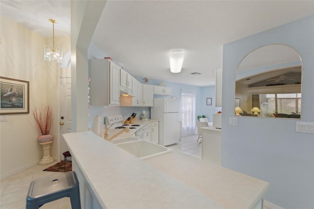 kitchen featuring sink, ceiling fan with notable chandelier, light tile patterned floors, white appliances, and hanging light fixtures