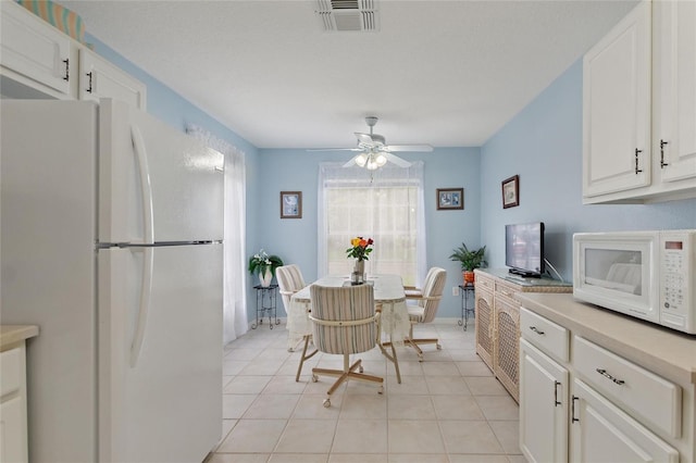 kitchen featuring white cabinets, light tile patterned floors, white appliances, and ceiling fan