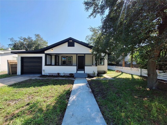 view of front of property with a front lawn, a porch, and a garage