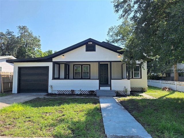 view of front of house with a porch, a garage, and a front lawn