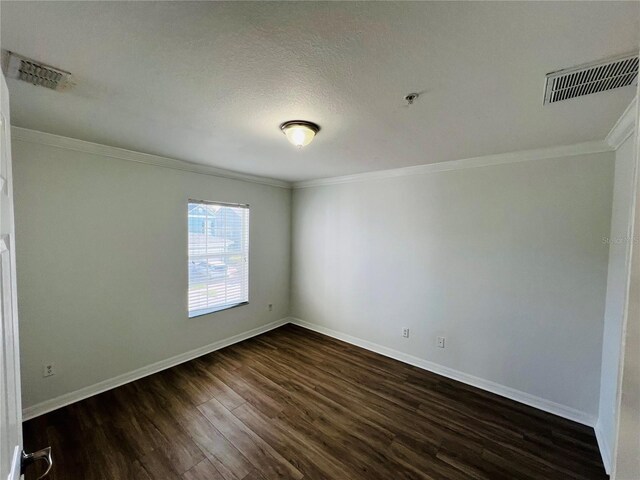 unfurnished room with a textured ceiling, crown molding, and dark hardwood / wood-style floors