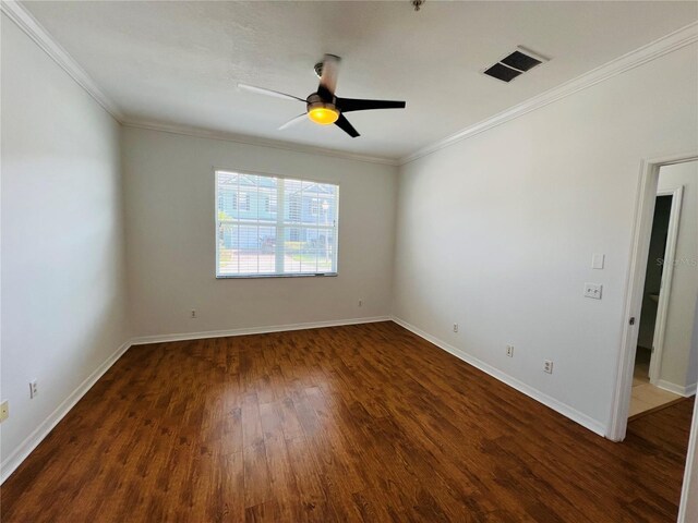 empty room with ceiling fan, dark wood-type flooring, and crown molding