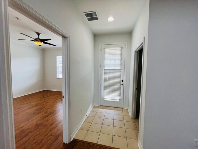 hallway featuring crown molding and light tile patterned flooring