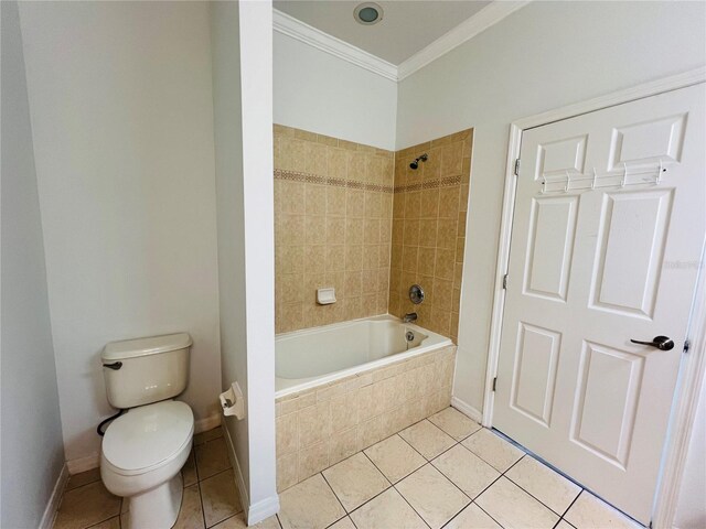 bathroom featuring tiled shower / bath, toilet, tile patterned floors, and ornamental molding