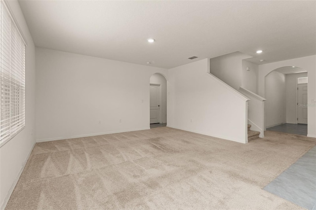 unfurnished living room with light colored carpet