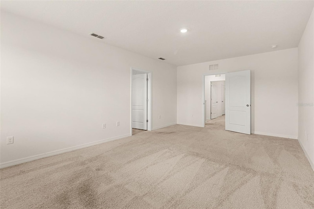 spare room featuring light colored carpet