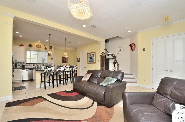 tiled living room featuring sink and a notable chandelier